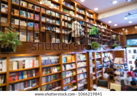 Blurred abstract background of bookshelves in book store, with a girl reading book in the store.