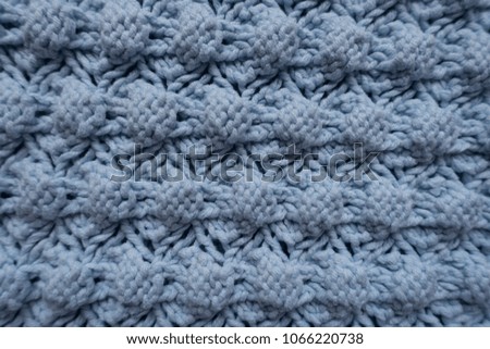Texture of light blue knitted fabric with relief pattern