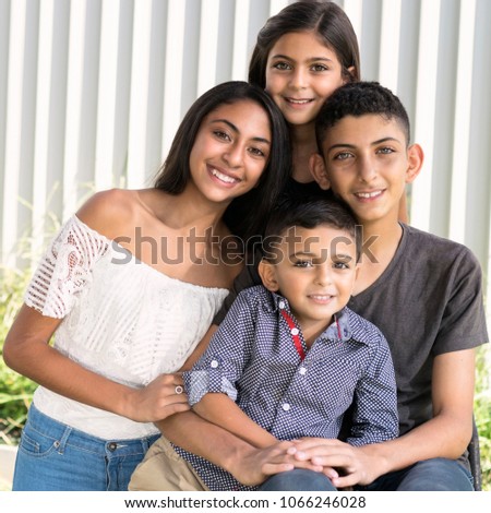 Smiling siblings in garden.
Outdoor portrait of two brothers and two sisters, blurred white fence background.
 Royalty-Free Stock Photo #1066246028
