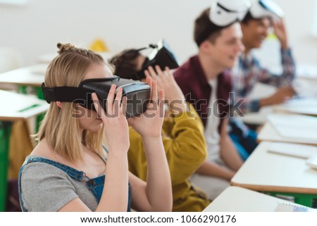 Side view of high school students taking off virtual reality headsets 