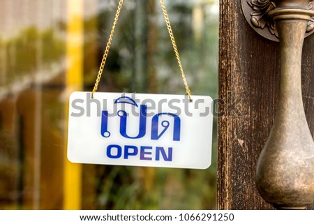 Open sign board hanging on a glass door of coffee shop