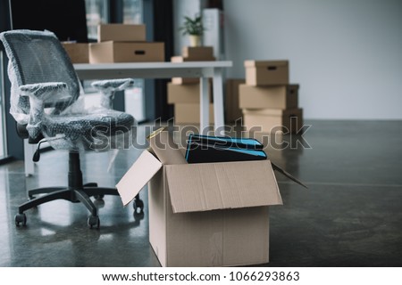 cardboard box with folders and office supplies in floor during relocation Royalty-Free Stock Photo #1066293863