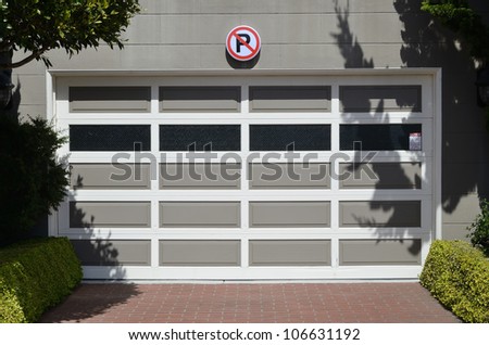 Access to a garage with a no parking sign displayed above the door