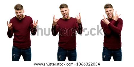 Handsome blond man making rock symbol with hands, shouting and celebrating isolated over white background