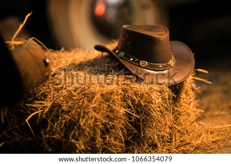 Leather Cowboy Hat on the Small Pile of Hay in the Old Barn. Western Wear and Wild West Concept. Royalty-Free Stock Photo #1066354079