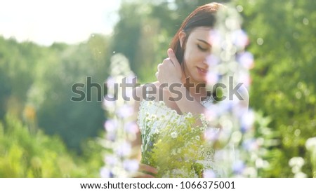 happy girl in a field with flowers in nature. girl in a field smiling woman holding a outdoor bouquet of flowers
