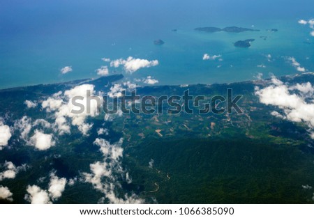 Aerial view of land and blue sea from airplane window. Thailand landscape, top view