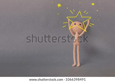 A toy man on a gray background with copy space. Presentation PowerPoint or Keynote. Motivational phrase. A sketch is drawn on top of the photo.Man holding a big star