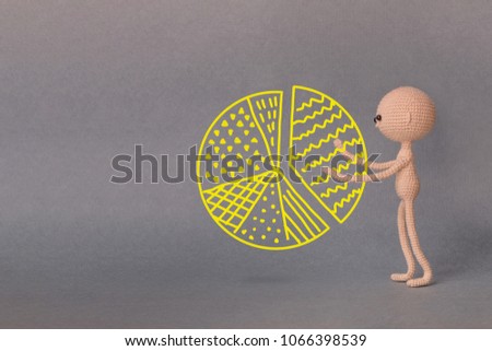 A toy man on a gray background with copy space. A sketch is drawn on top of the photo. Presentation PowerPoint or Keynote. Man takes a piece of cake - part of the graph. 