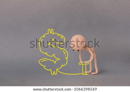 A toy man on a gray background with copy space. Presentation PowerPoint or Keynote. Motivational phrase. A sketch is drawn on top of the photo.A man inflates a dollar sign