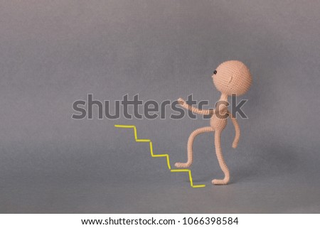 A toy man on a gray background with copy space. Presentation PowerPoint or Keynote. Motivational phrase. A sketch is drawn on top of the photo.Man climbs the stairs up