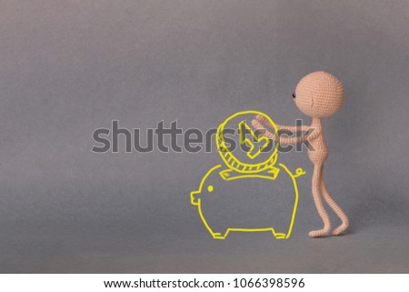 A toy man on a gray background with copy space. Presentation PowerPoint or Keynote. Motivational phrase. A sketch is drawn on top of the photo.A man puts one coin in a piggy Bank