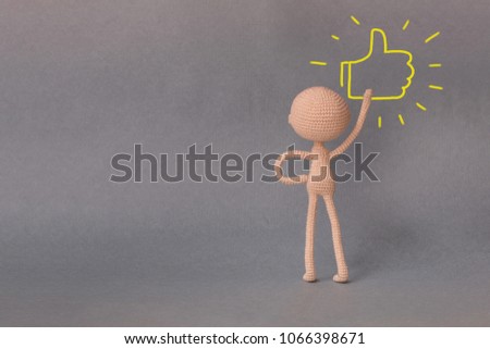 A toy man on a gray background with copy space. Presentation PowerPoint or Keynote. Motivational phrase. A sketch is drawn on top of the photo.A person presses the Like button.