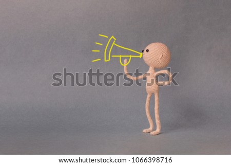 A toy man on a gray background with copy space. Presentation PowerPoint or Keynote. Motivational phrase. A sketch is drawn on top of the photo.The man with the megaphone tells the truth at the rally.