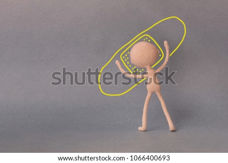 A toy man on a gray background with copy space. Presentation PowerPoint or Keynote. Motivational phrase. A sketch is drawn on top of the photo.A man pasting a sticking plaster