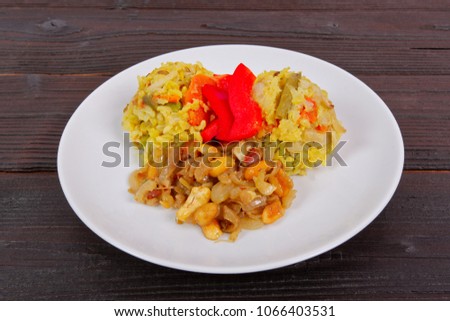 Risotto with vegetables and nuts on a wooden table