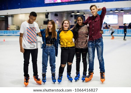 Group shot of teenage friends on the rink ice skating rink
