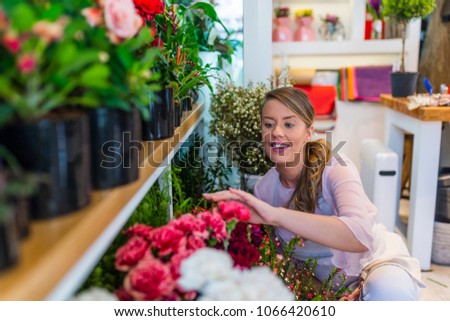 Business of flower shop with woman owner. Florist arranging bouquet of flowers in vase.Smiling florist arranging flowers. Flowers delivery, creating order.