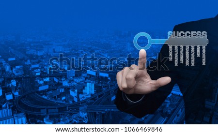 Businessman pressing key icon with business words over modern city tower, street and expressway, Success business concept
