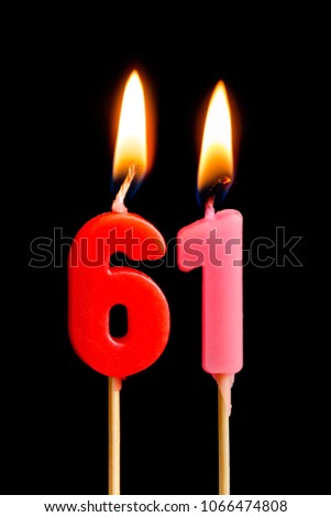 Burning candles in the form of 61 sixty one (numbers, dates) for cake isolated on black background. The concept of celebrating a birthday, anniversary, important date, holiday, table setting
