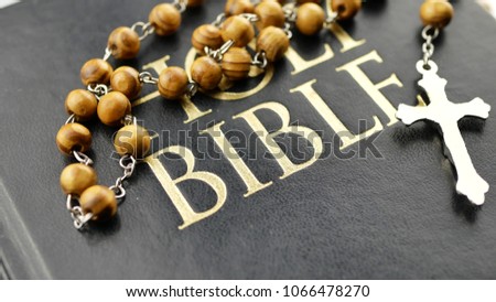 Holy bible and cross with wooden chain