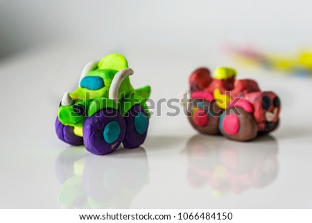 Carts made from plasticine on white background, children's games. Shallow depth of focus.