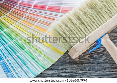 Horizontal image of color palette fan paint brush on wood board