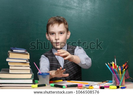 The pupil mades magical passes against the background of the green board