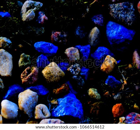 Textural background. Photo of a path covered with colored stones.