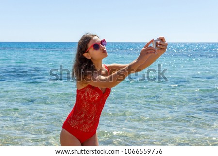 young girl having fun taking smartphone selfie pictures of herself. travel holidays.