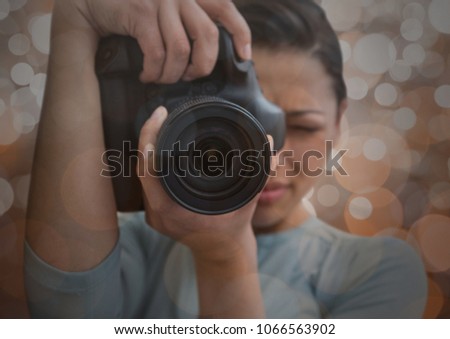 photographer foreground taking a photo with reflex. Blurred brown lights background and overlap