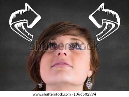 Woman looking up at white curved arrows against grey wall