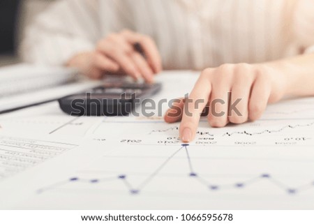 Closeup of woman hands working with financial documents and counting on calculator. Financial background, count and pay an account, copy space, selective focus