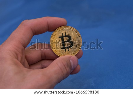 golden bitcoin in man hand