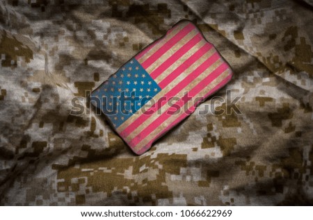 Grungy and dirty American flag on desert camouflage background