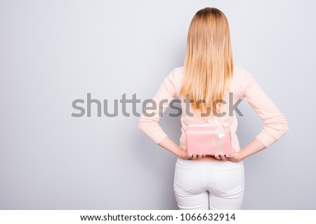 Win winner luck rest relax chill new lovely trend person concept. Back rear view photo of attractive woman with long blonde hair hiding wrapped present box behind her back isolated on gray background