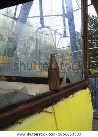 Brown beer or lemonade bottle on the edge of a building in Pripyat amusement park in the aftermath of Chernobyl disaster. Broken windows, loneliness, doom and alcohol in one picture