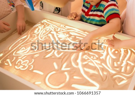 Children paint in the interactive sand table , sand animation