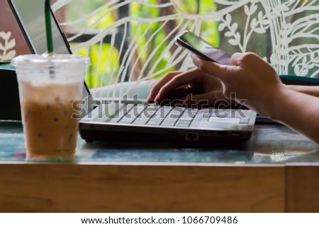 People use notebooks and cell phones to work in coffee shops and coffee blur.