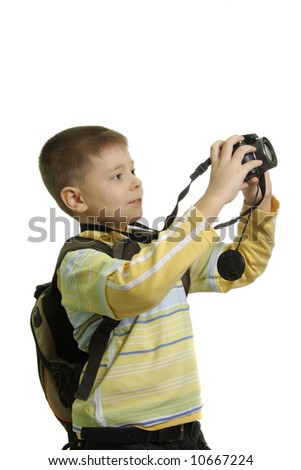 Boy in yellow with backpack making photos isolated