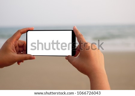 A woman holding a smartphone empty taking a photo