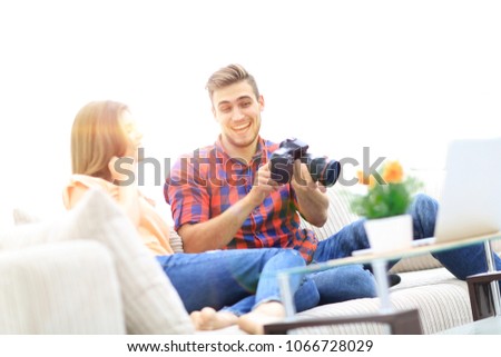 young man shows a photo of his girlfriend sitting in the living room