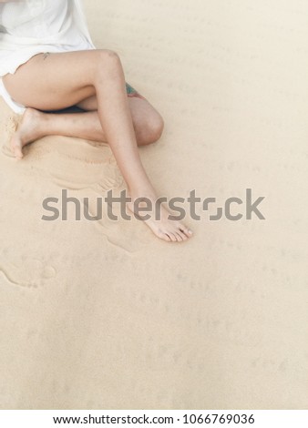 Skinny girl’s legs at sand dunes background