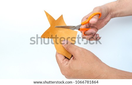 Asian man is cutting a brown paper into star shaped