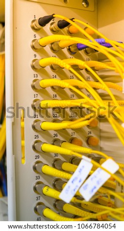 Fiber optic cables in box's connection in a technology data center room for high speed communication. Light effect and selective focus