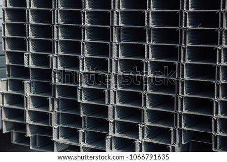 Construction steel profile pipe of rectangular shape with corrugated surface in warehouse.