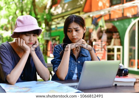 Travel Concept. A tourist girl searching for accommodation on the internet and map. Asian women playing computer.