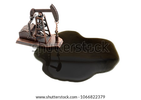Petroleum industry, petrodollar and crude oil concept : Pump jack and black oil spill on white background. Pumpjack is common in oil rich area and used for onshore wells producing or extracting oil. Royalty-Free Stock Photo #1066822379