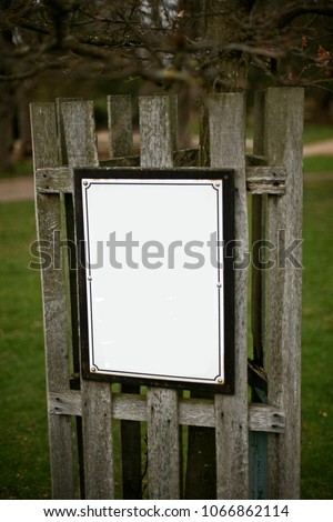 Simple tree sign at wooden fence in the green park for preserving forest ,information and direction sign.