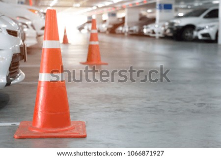Red traffic cones at parking area in daytime.